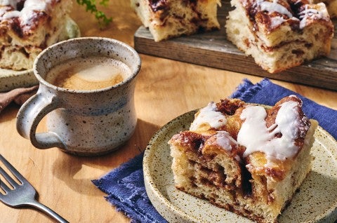Cinnamon Roll Focaccia on a plate with a cup of coffee