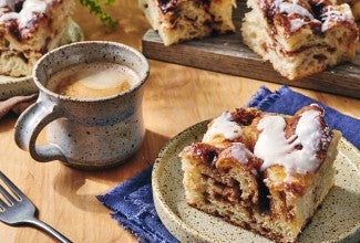 Cinnamon Roll Focaccia on a plate with a cup of coffee
