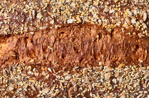 Top view of Multigrain Protein Bread with seeds and a deep brown crust. - select to zoom