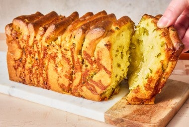 A slice of Jalapeño-Cheddar Pull-Apart Bread being pulled from the loaf