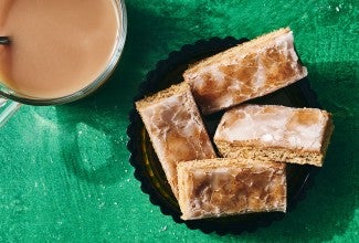 Lebkuchen bars on a plate with a beverage in the corner of the corner of the photo.