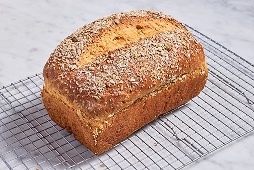 Multi-grain protein bread fresh out of the oven and placed on a wire rack for cooling.