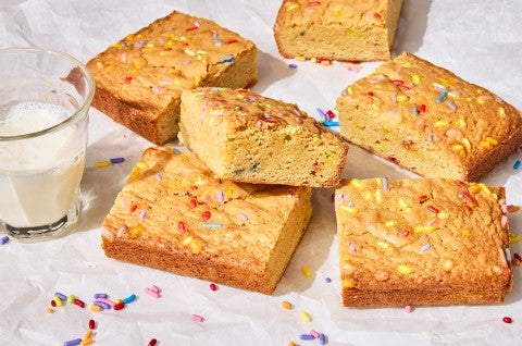 Small-Batch Birthday Cake Blondies on a counter with a glass of milk
