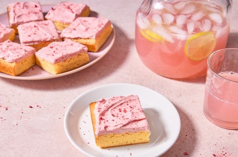 Strawberry Lemonade Bars served on a plate with a pitcher of strawberry lemonade - select to zoom