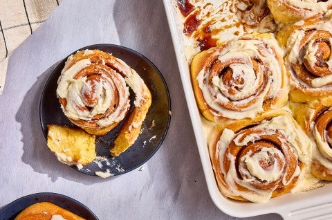 A Sweet Potato Cinnamon Roll on a plate; a bunch in a casserole dish