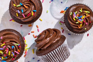 Small-Batch Chocolate Cupcakes casually arranged on a counter with sprinkles dotted about.